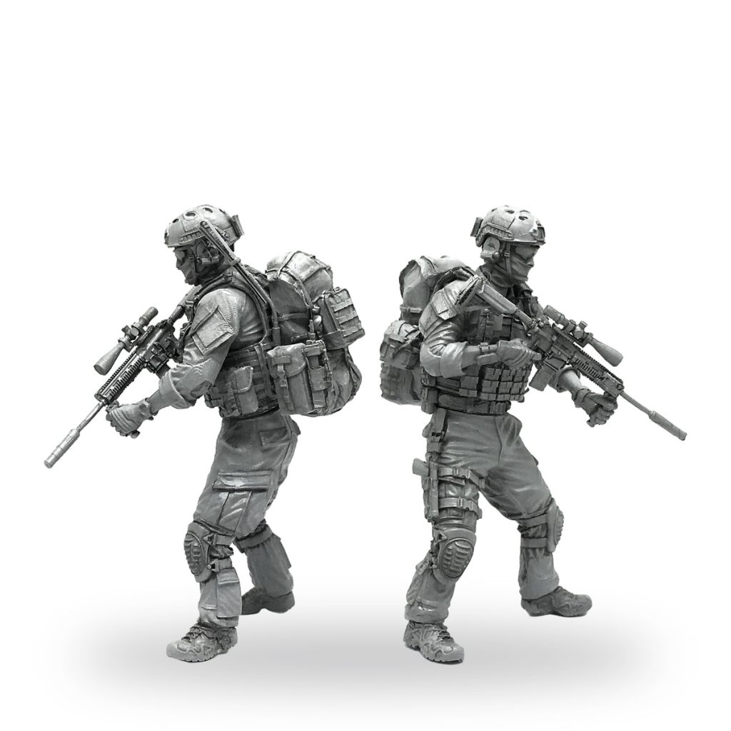 Unpainted 1/35 scale American Special Forces soldier figures in combat gear with rifles and backpacks.
