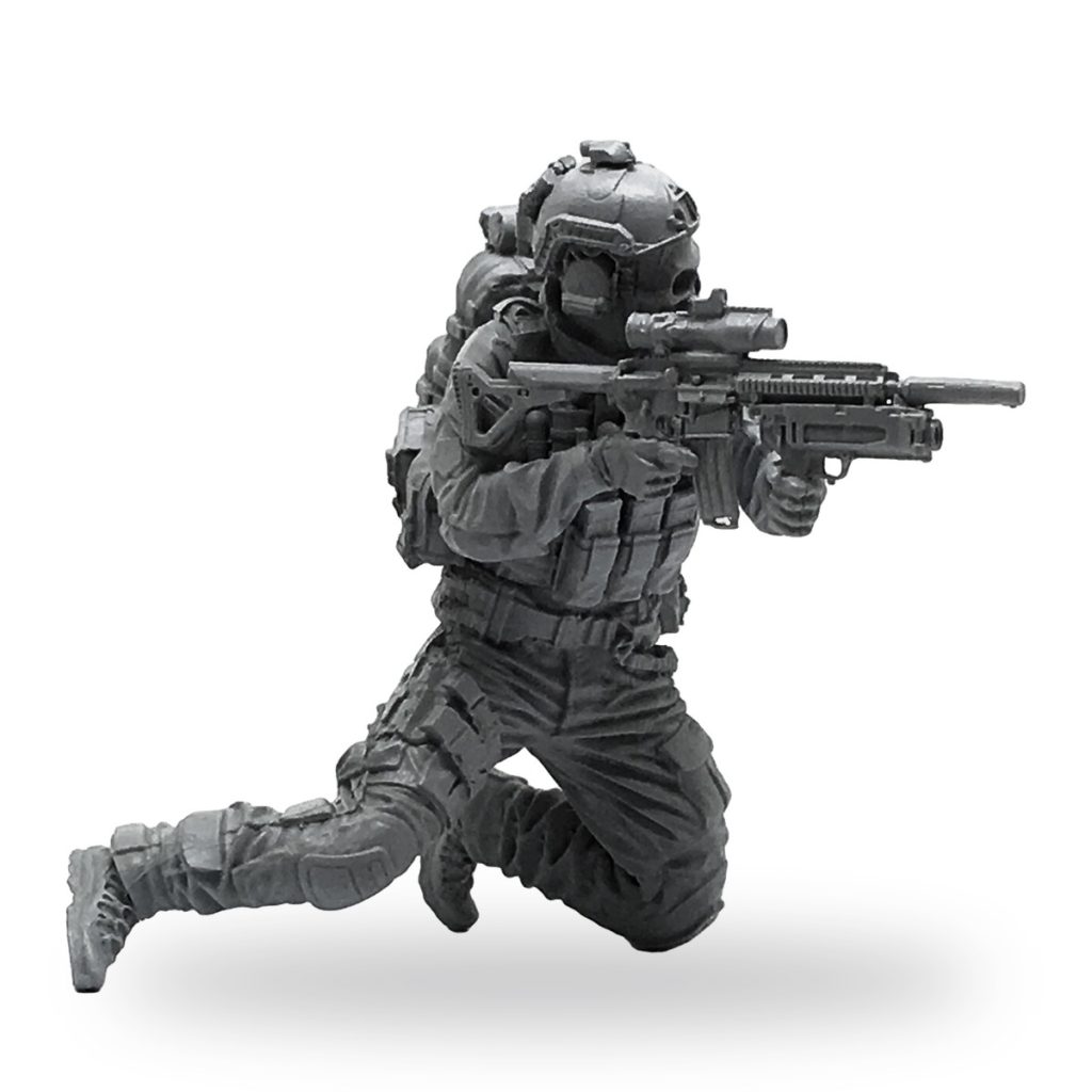 Unpainted 1/35 scale modern soldier in tactical gear aiming assault rifle.
