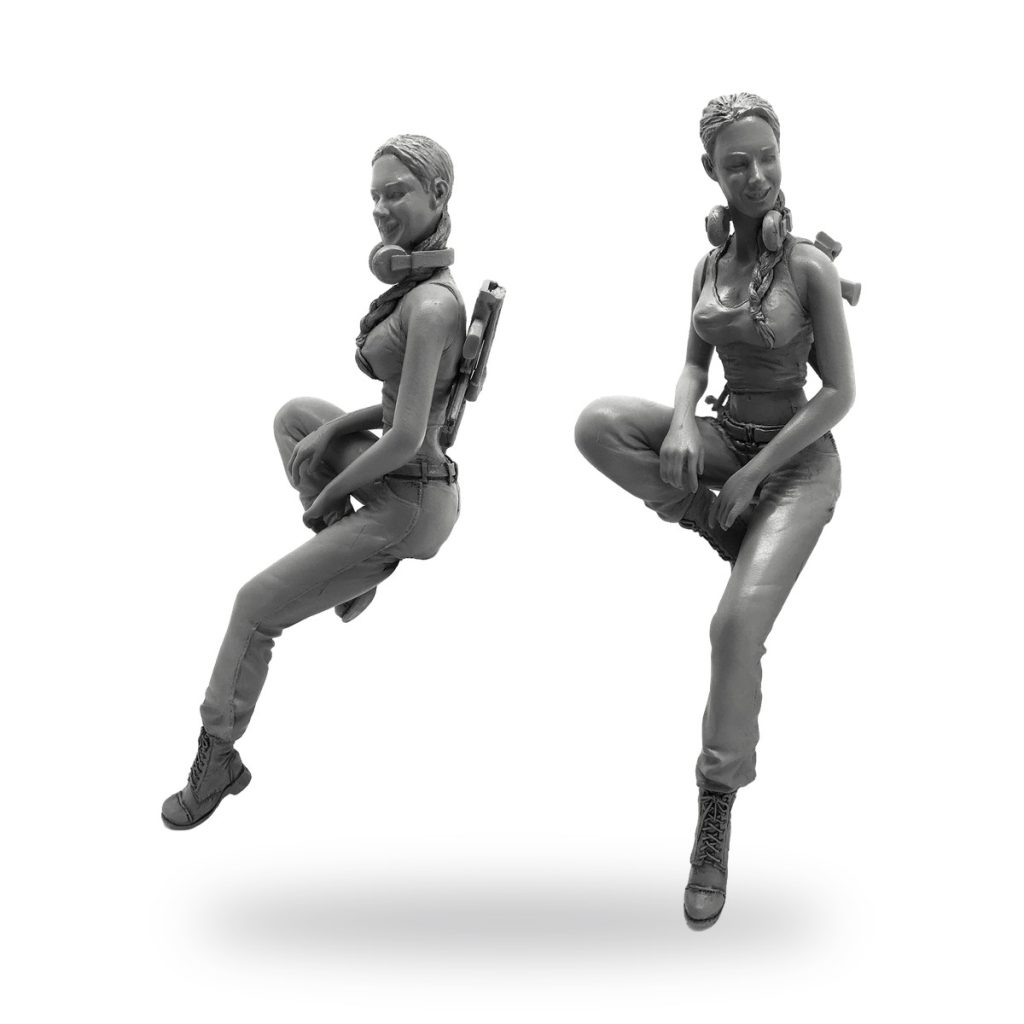Unpainted female soldier miniature in sitting pose with headphones and backpack.