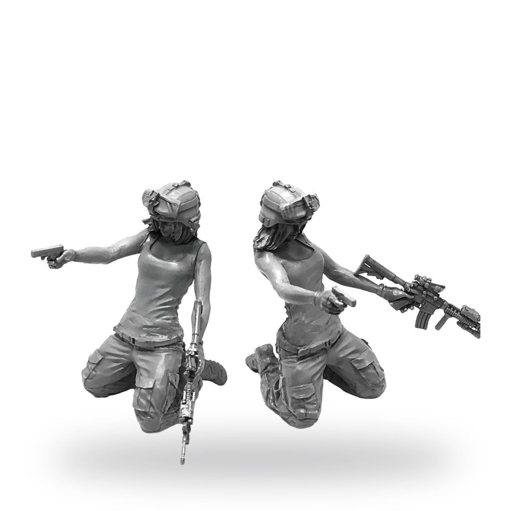 Two female soldiers in tactical gear kneeling with firearms.