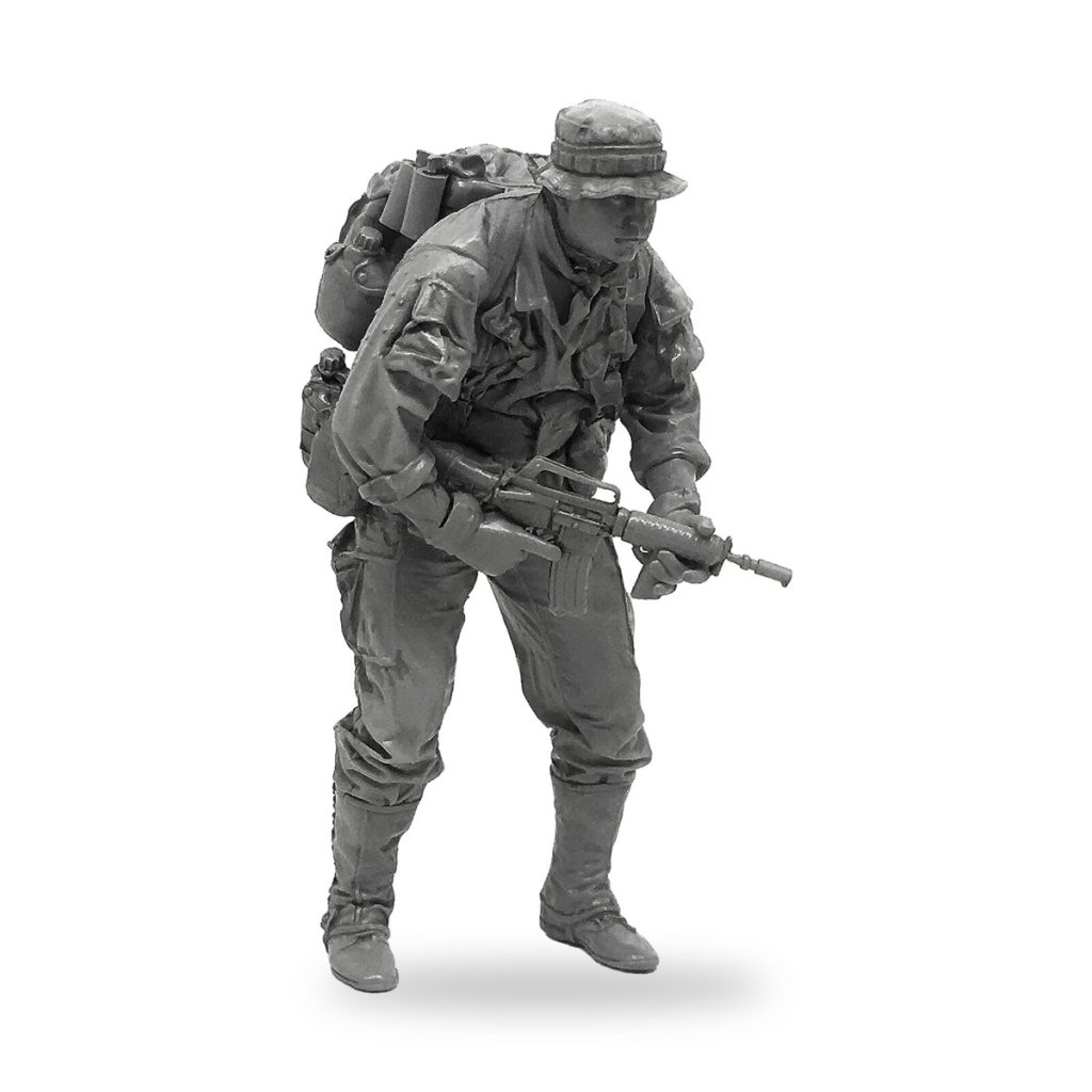 Unpainted 1/35 US soldier miniature with rifle and backpack in combat stance.