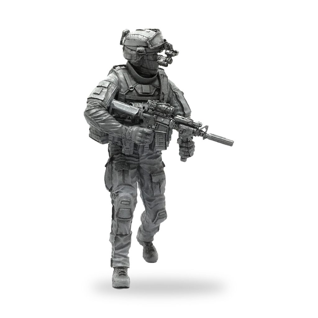 Unpainted 1/35 scale US Marine soldier miniature in tactical gear holding rifle.