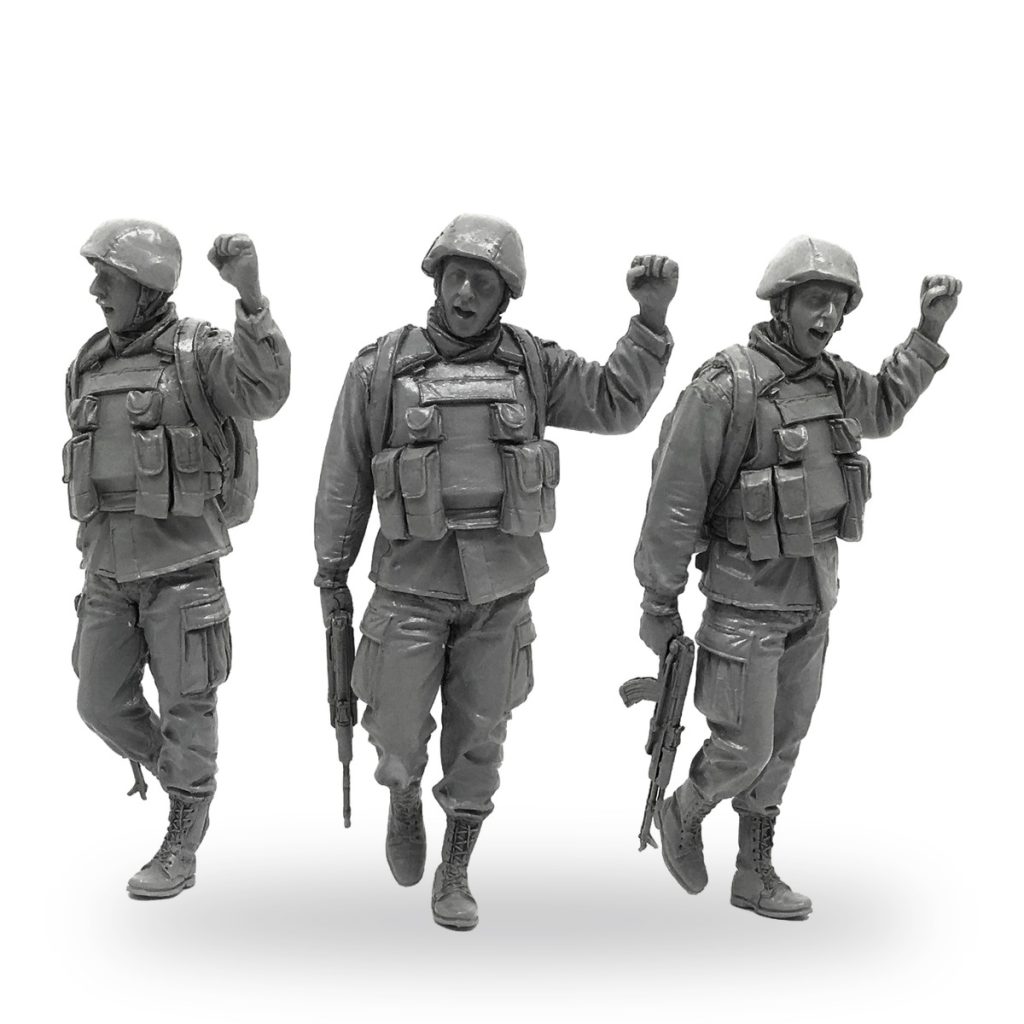 Three unpainted 1/35 scale soldier figures celebrating victory with raised fists and rifles.