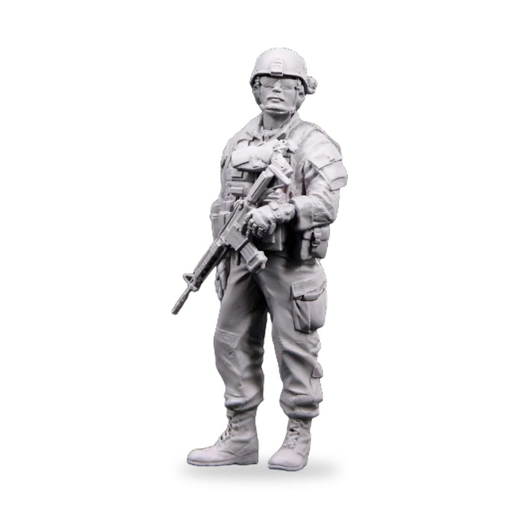Unpainted US soldier figure holding rifle in combat gear.