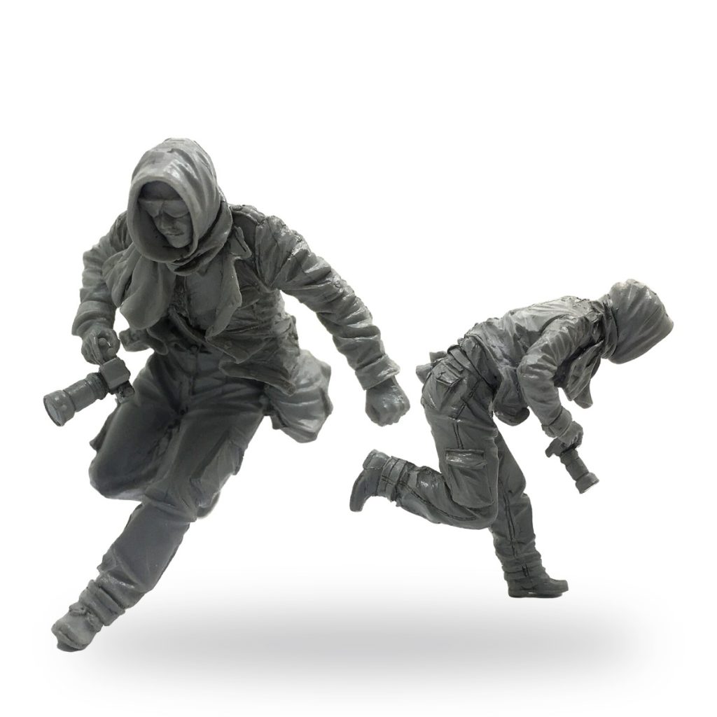 Unpainted resin figures of war journalists with cameras in action poses.