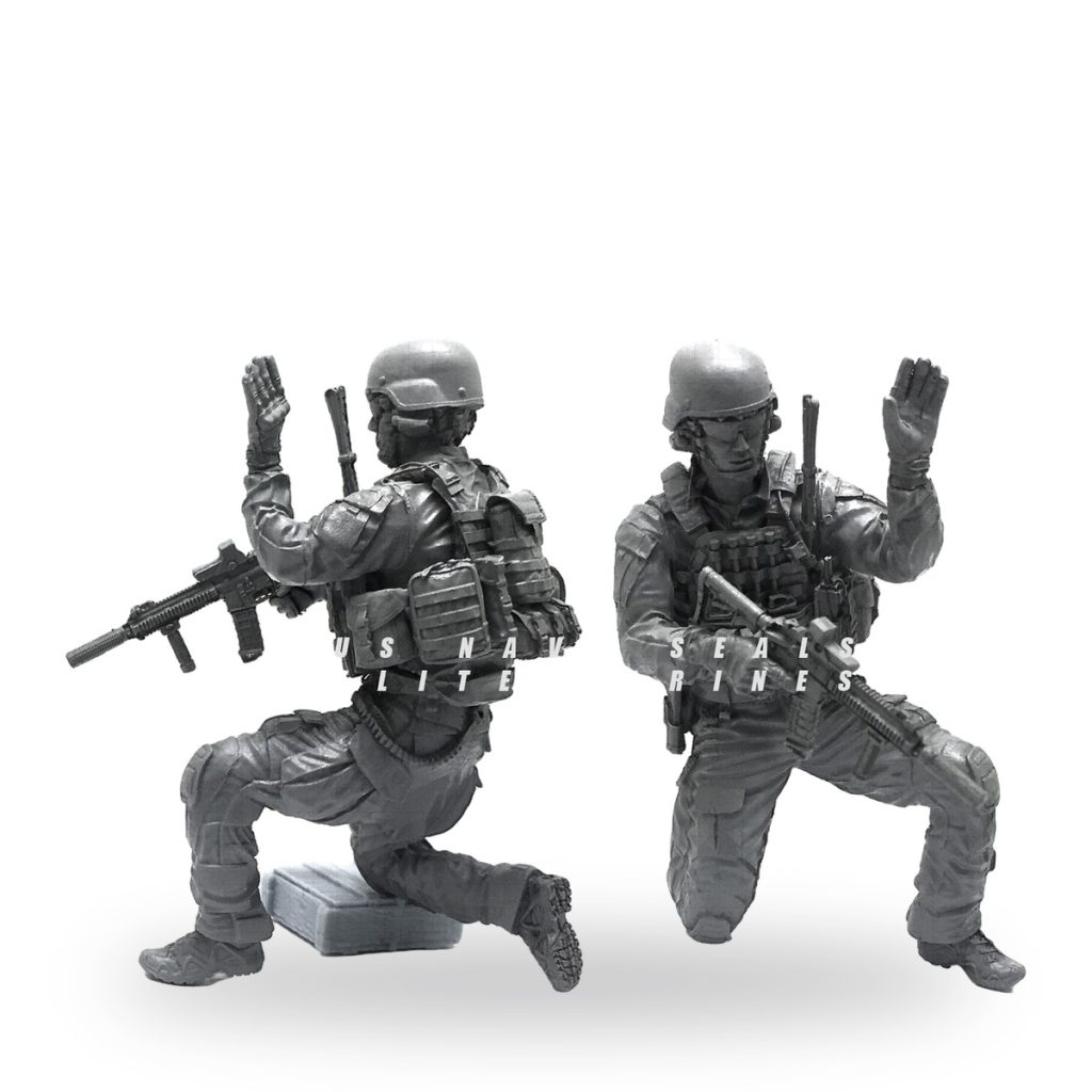 Unpainted US Navy SEALs figure in tactical gear with rifles and raised hands.